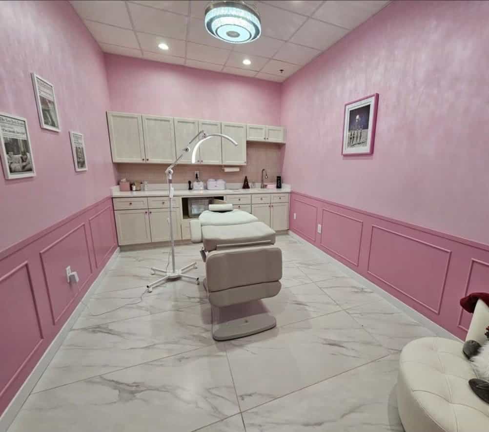 Commercial spa treatment room finished in pink with painted wainscoting and cabinetry