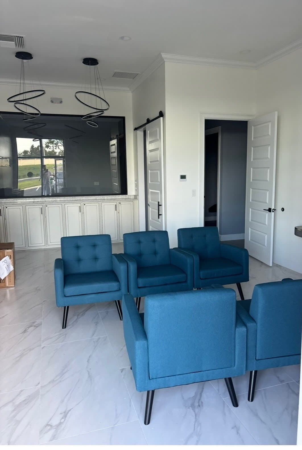 Commercial waiting area with freshly painted white built-in cabinetry and blue armchairs