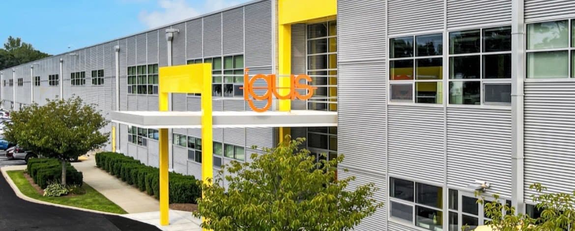 Industrial building exterior with a repainted yellow entrance canopy and signage accents