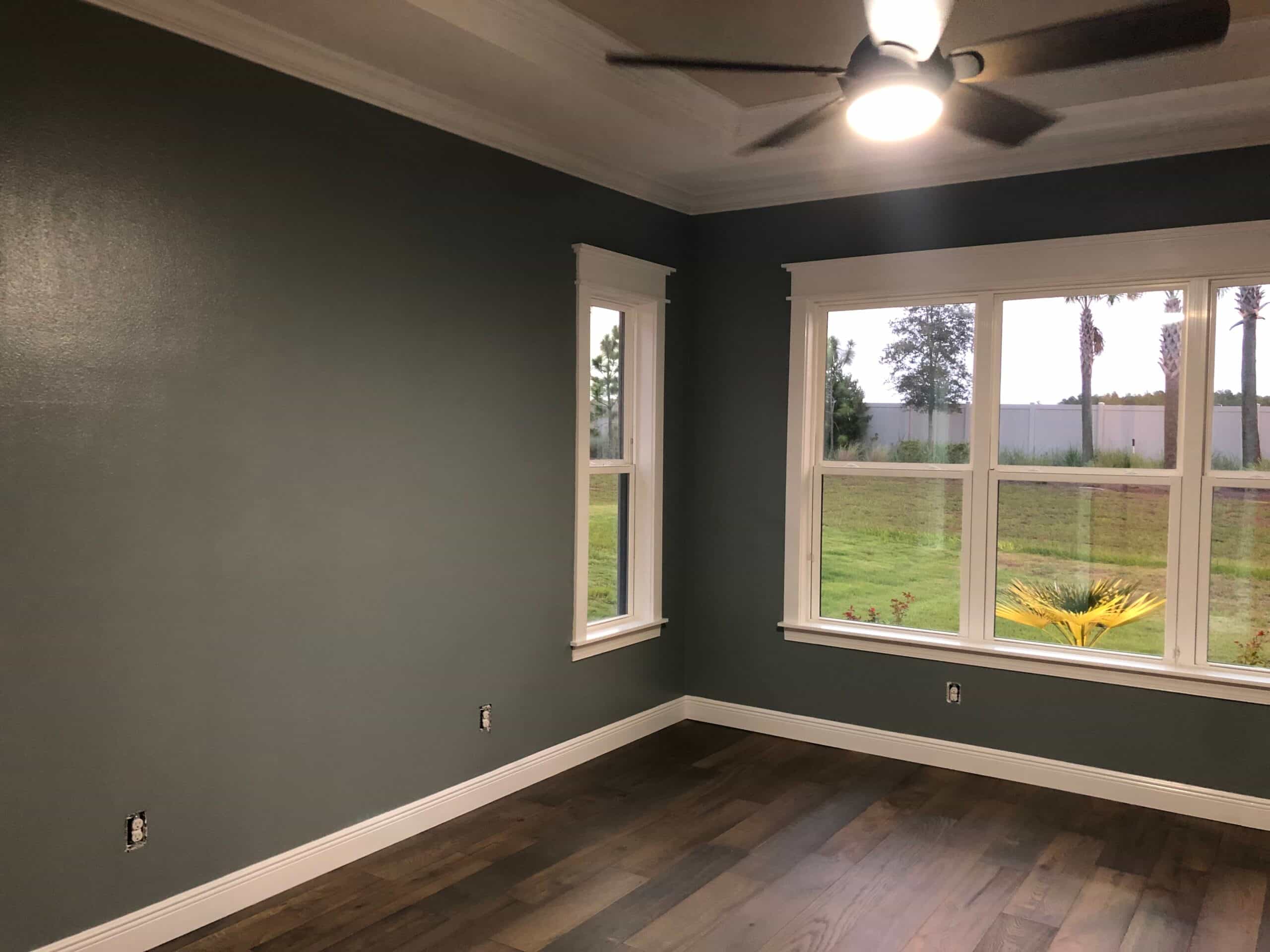 Custom home interior painted a deep gray-green with crisp white trim and crown molding