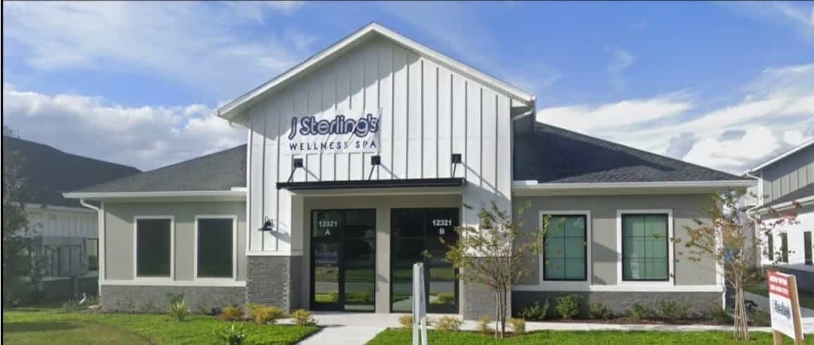 Commercial exterior repaint of a wellness spa in white and gray with black fixtures