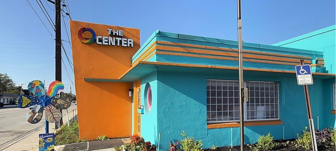 Commercial building exterior repainted in bright teal and orange
